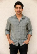 Men wearing grey crush linen check shirt with rolled sleeves and denim jeans
