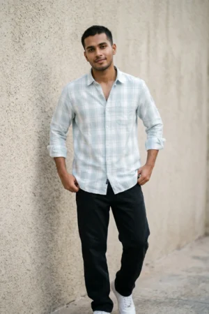 Man wearing a heavy mill-made TFO Oxford windowpane check shirt with double shoulder construction in sky blue and white, full sleeves rolled at cuffs, black trousers