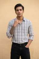 Man wearing a heavy mill-made TFO Oxford windowpane check shirt with double shoulder construction in grey and white, full sleeves rolled at cuffs, black trousers