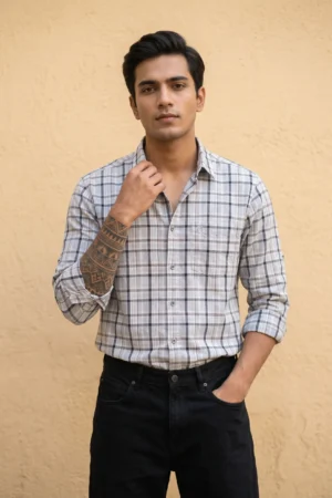 Man wearing a heavy mill-made TFO Oxford windowpane check shirt with double shoulder construction in grey and white, full sleeves rolled at cuffs, black trousers