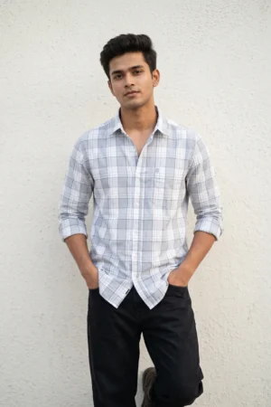 Man wearing a heavy mill-made TFO Oxford windowpane check shirt with double shoulder construction in grey and white, full sleeves rolled at cuffs, black trousers